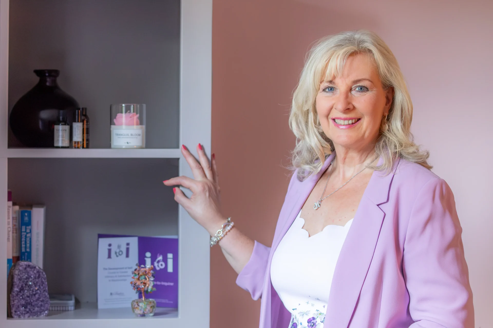 Sue Weller standing beside a bookshelf.
